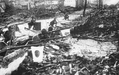 Japanese soldiers aiming rifles with flags hanging from their barrels