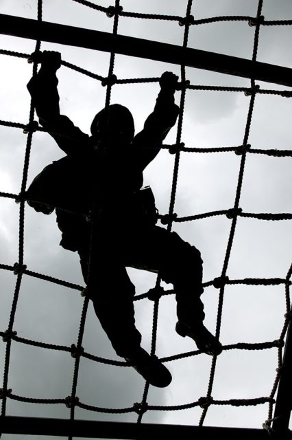 Soldier climbing a grid rope