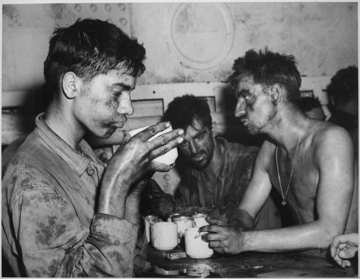 Трое морских пехотинцев США сидят за столом и пьют кофе.