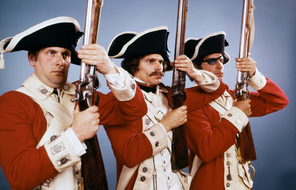 Three re-enactors dressed as British soldiers during the American Revolution