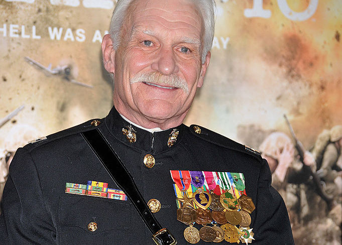 Dale Dye standing on a red carpet in his US Marine Corps uniform