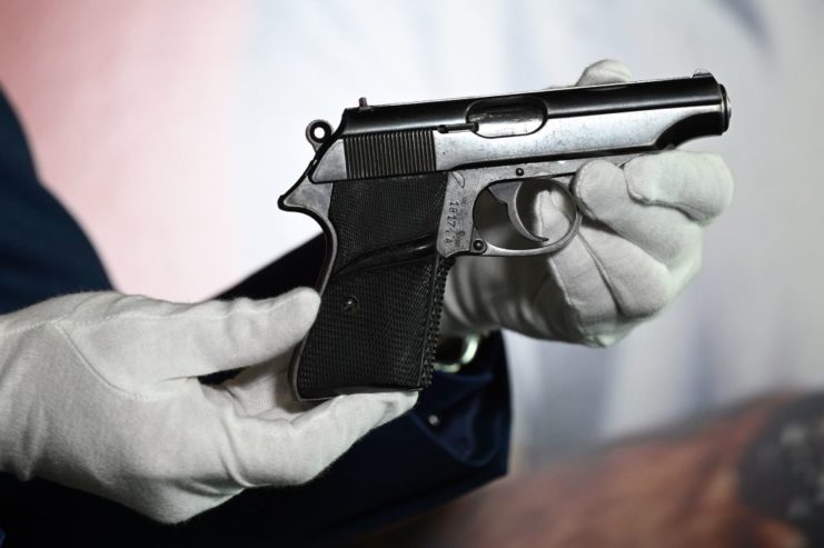 Gloved hands holding a Walther PP pistol