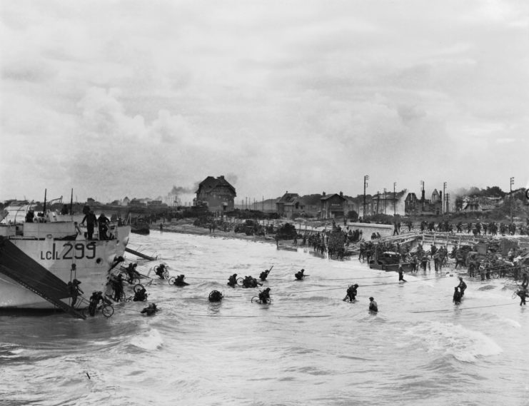 Soldiers wading through water after disembarking from a sea vessel