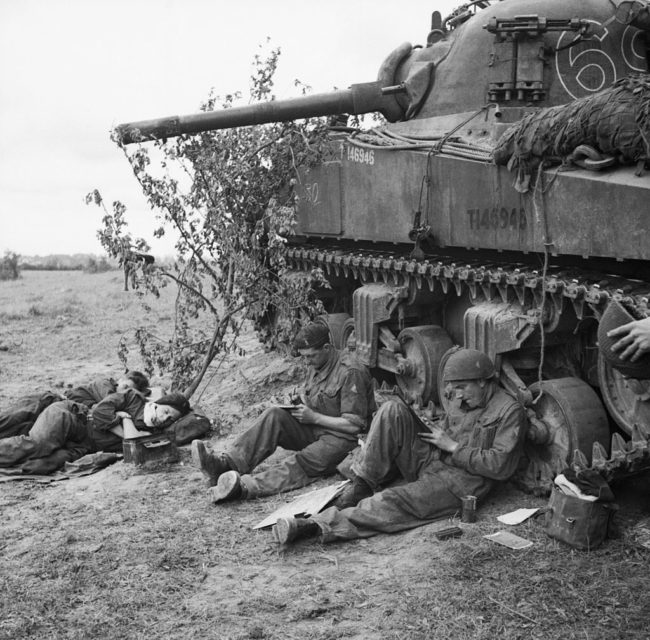 British soldiers writing letters while sitting beside their M4 Sherman
