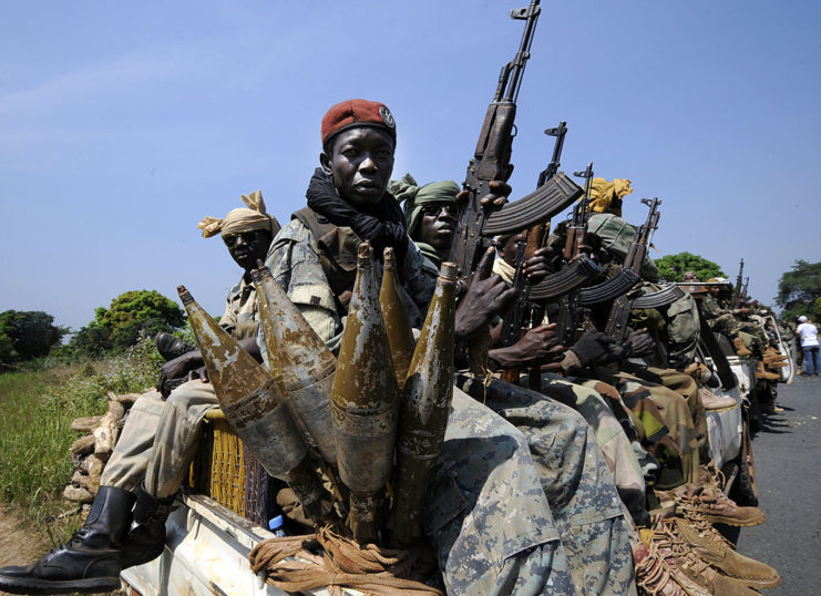 Armed Chadian soldiers sitting in the bed of a pickup truck