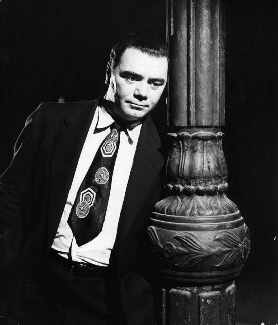 Ernest Borgnine leaning against a lightpost