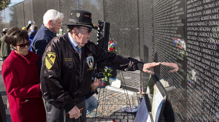 Joe Galloway standing with others at the Vietnam Memorial Wall