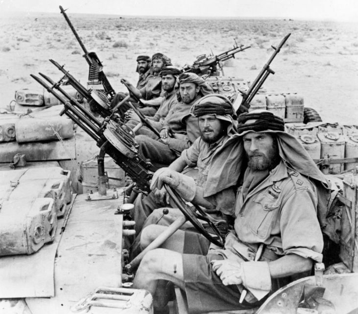 Armed members of the Special Air Service (SAS) sitting in trucks in the desert
