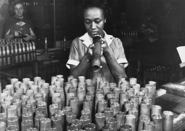 Female worker staring into an artillery shell