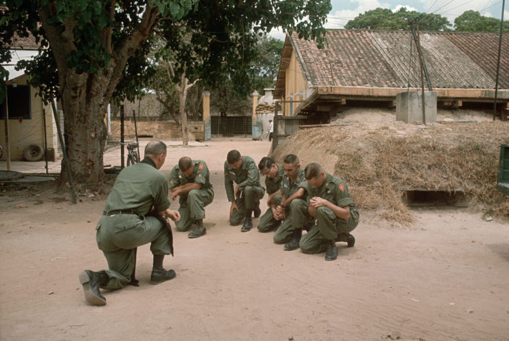 A US Army chaplain and MACV-SOG members knelt in prayer
