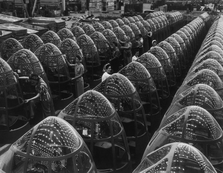 Female workers polishing aircraft nose cones lined up along a factory floor