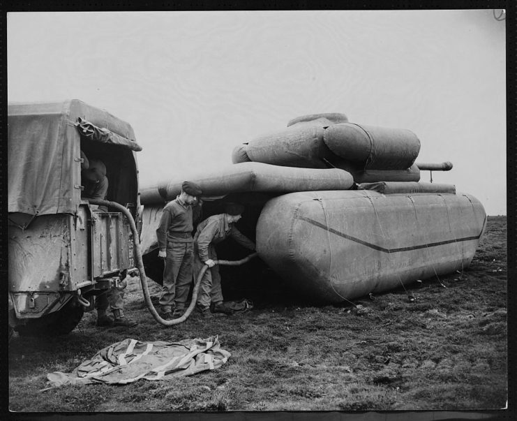 Two soldiers filling an inflatable tank with air
