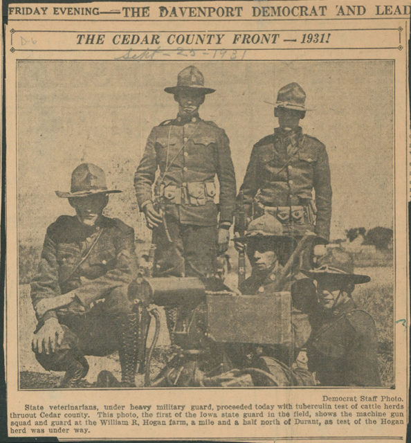 Newspaper clipping of five National Guard members standing outside with equipment