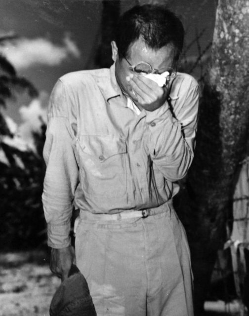 Japanese prisoner of war (POW) covering his face with a tissue