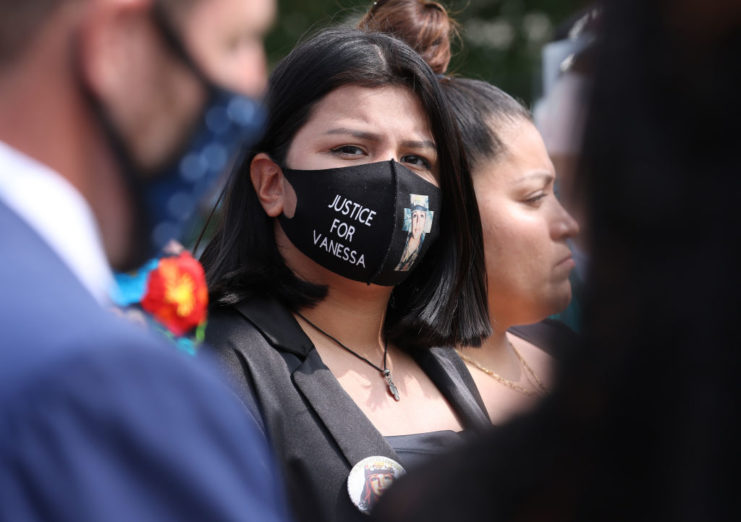 Lupe Guillén standing in a crowd while wearing a "JUSTICE FOR VANESSA" face mask