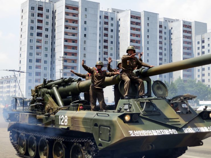 Four North Korean soldiers standing on top of an M-1989 Koksan
