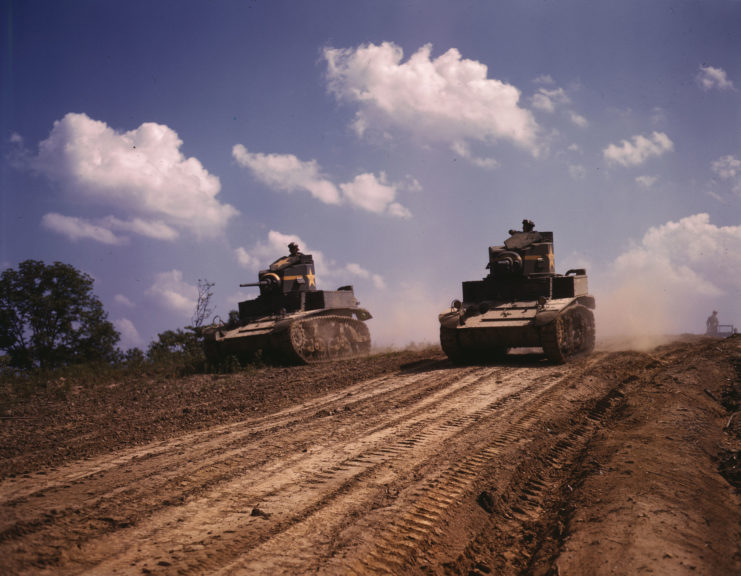 Two M3 Stuarts driving down a dirt road