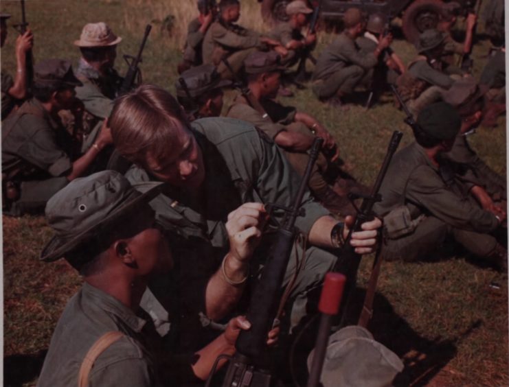 Richard Mooney helping a Regional Forces soldier adjust his M16 rifle