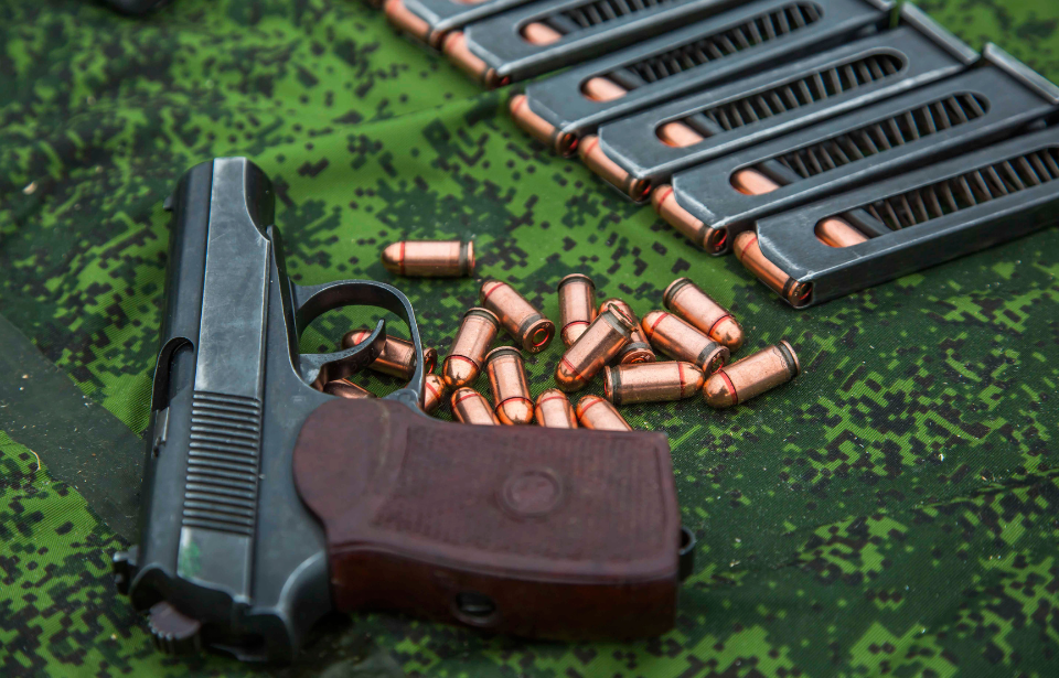 Makarov pistol and bullets placed upon a camouflage sheet