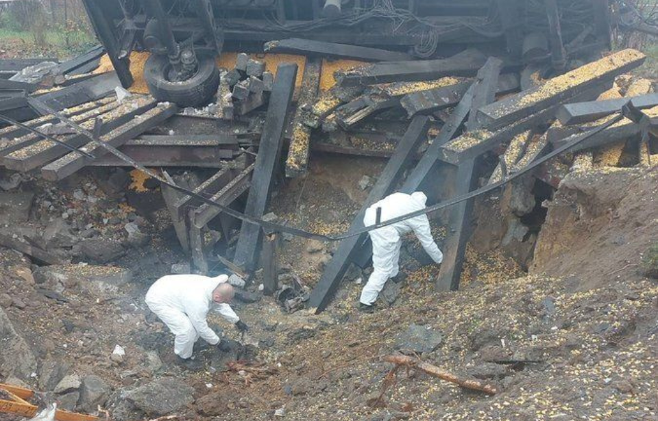 Two Polish police officers in a crater caused by a missile strike