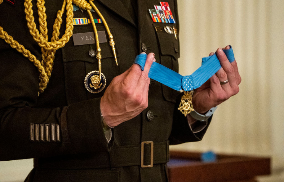 Military aide holding the Medal of Honor