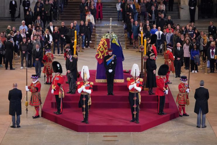 Queen Elizabeth II's grandchildren standing vigil around her coffin while members of the public walk through Westminster Hall