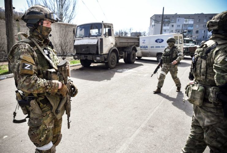 Three Russian soldiers standing in the middle of a street