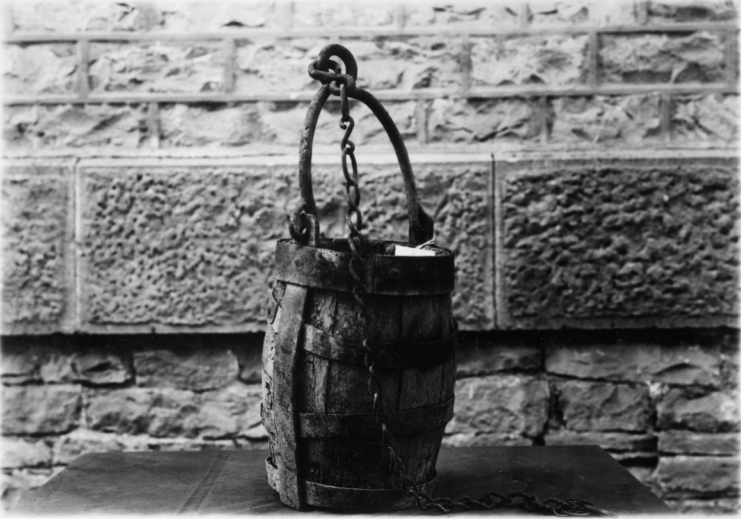 Oaken bucket hanging from a brick wall