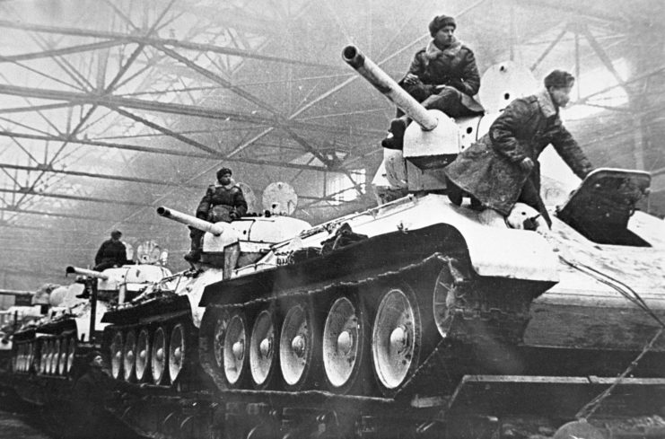 Russian soldiers standing atop a row of T-34s