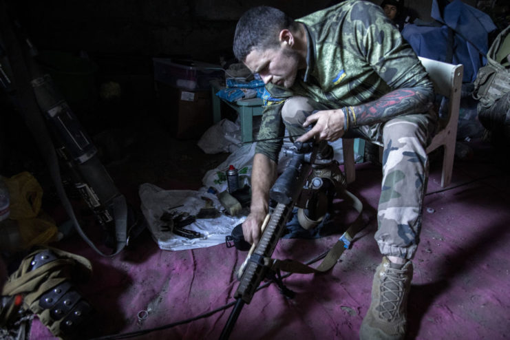 Ukrainian sniper cleaning his rifle