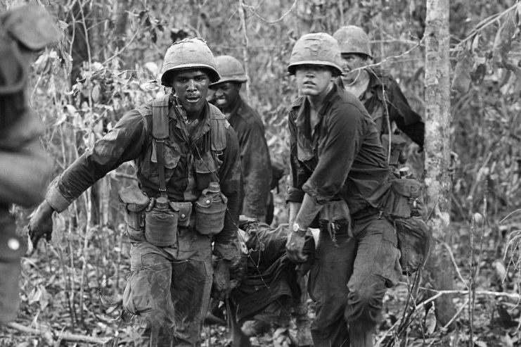 Four soldiers carrying their wounded comrade on a stretcher