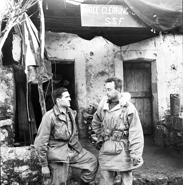 Lt. J. Kostelec and Lt. H.C. Wilson standing outside of a First Special Service Force (1SSF) building