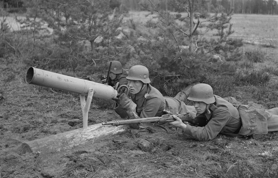 Finnish soldier aiming an Ampulomet while another aims a rifle