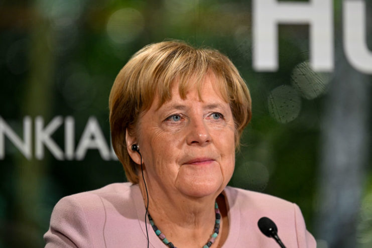 Angela Merkel sitting behind a microphone
