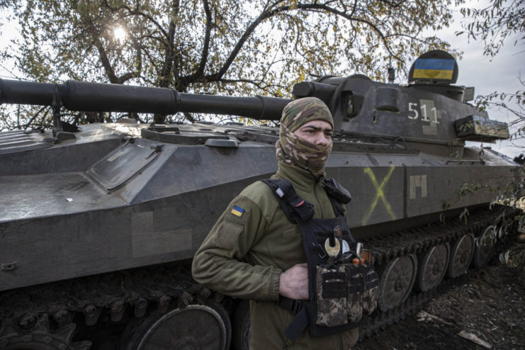 Ukrainian soldier standing in front of a tank