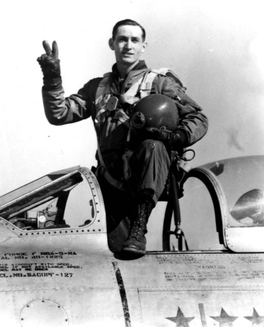 George Andrew Davis Jr. holding up a peace sign while standing in the cockpit of his aircraft