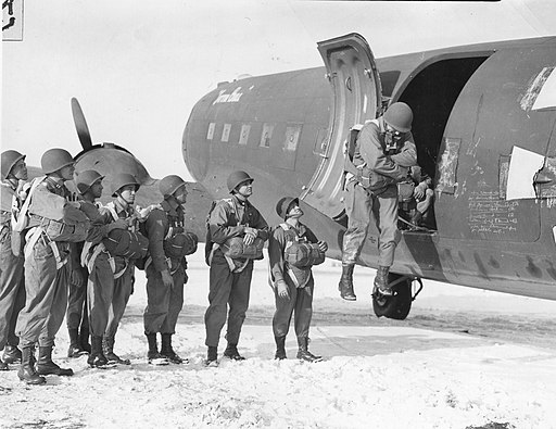 Volunteers with the First Special Service Force (1SSF) watching Capt. George F. Evashwick jump out of a grounded aircraft