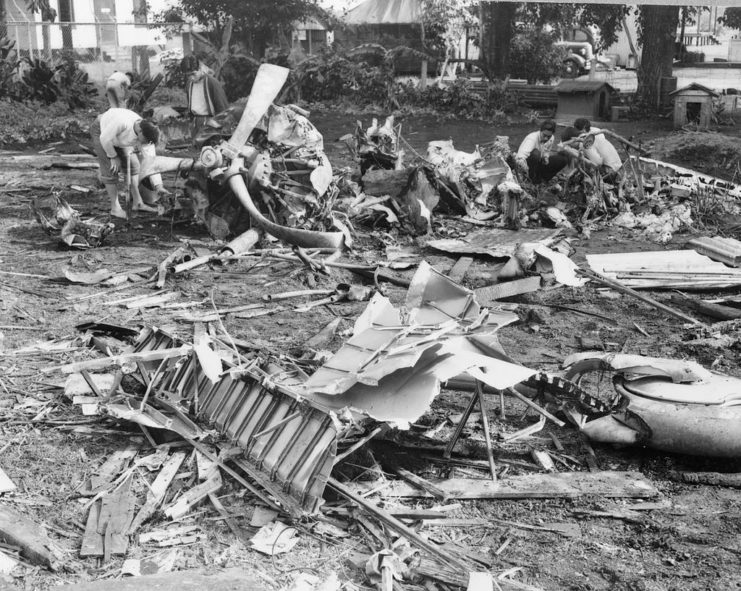 US Navy personnel standing among the remains of a downed Japanese bomber