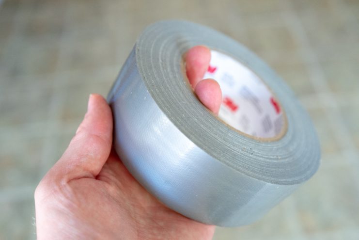 Hand holding a roll of duct tape