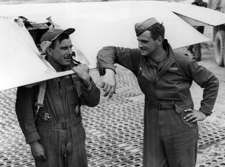 Two airmen inspecting a damaged Boeing B-17 Flying Fortress