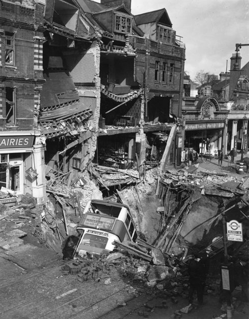 Double-decker bus stuck in a bomb crater in the middle of a street