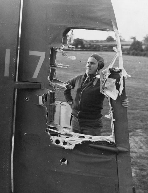 Airman examining a large hole in the wing of the Martin B-26 Marauder Idiot's Delight II