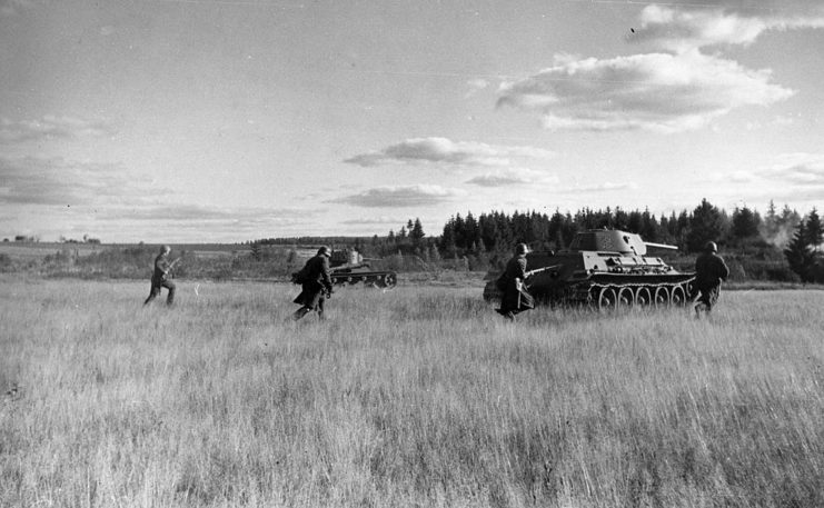 Soviet infantrymen walking behind a T-34