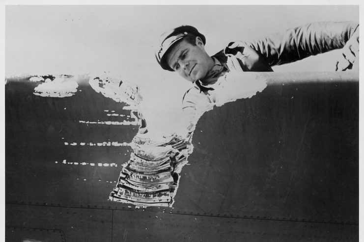 Lt. W.J. Hoelle staring at damage to a Lockheed P-38 Lightning