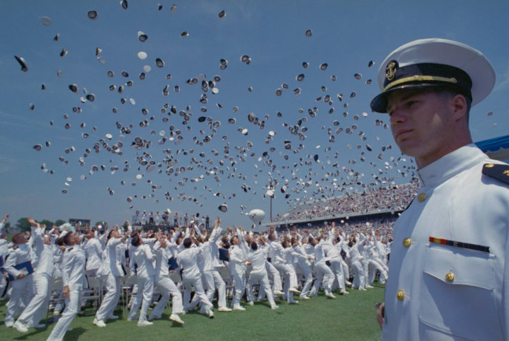US Naval Academy graduates tossing their caps into the air