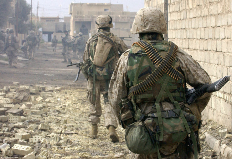 US Marines walking through a rubble-strewn street