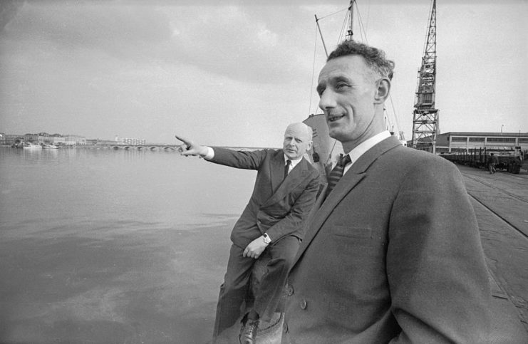 Herbert Hassler and Bill Sparks standing along the edge of the water