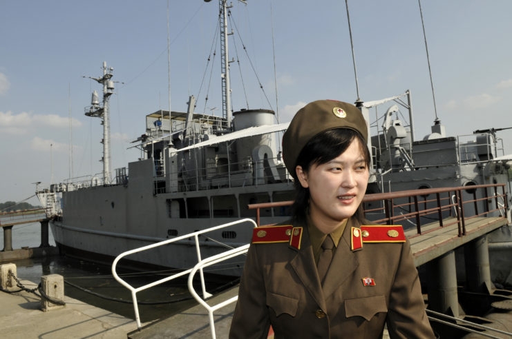 Female military member standing near the USS Pueblo (AGER-2)