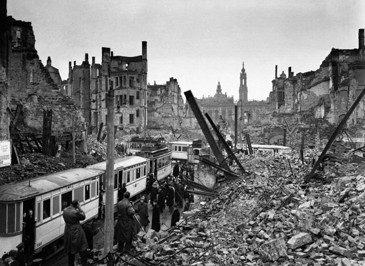 Residents walking through rubble along a street in Dresden, Germany