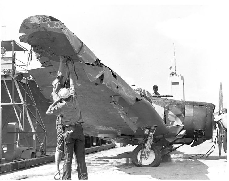 Ground crews repairing a damaged aircraft